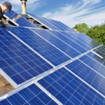 Rooftop solar panels installed on a modern suburban home under clear blue skies